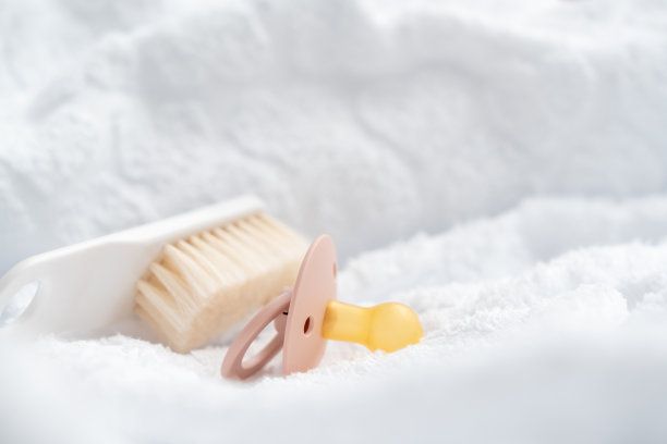 婴儿发刷和奶嘴在白色背景与毛巾。婴儿沐浴和卫生概念图片下载