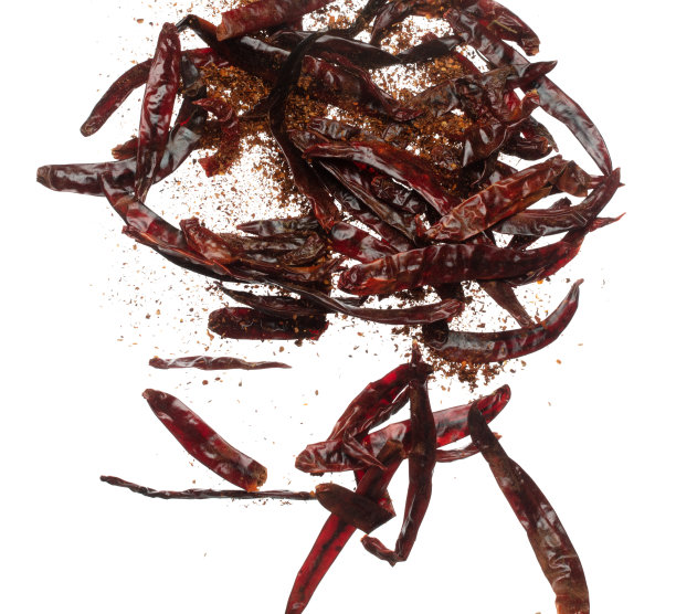 干红辣椒坠落爆炸，干红辣椒漂浮爆炸，抽象的云飞。混合粉末，辣椒粉在空气中飞溅。白色背景隔离高速快门，定格图片下载