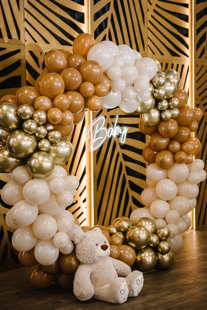 拱门上装饰着棕色、米色和金色的气球，短信宝贝。庆典洗礼概念。照片墙上的生日派对招待会。餐厅内庆祝活动的拍照区域和位置。图片下载