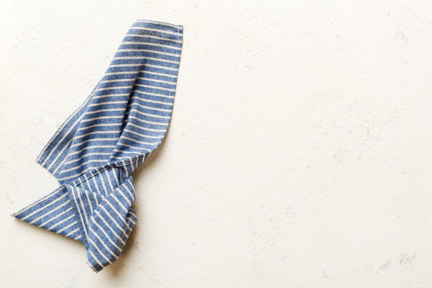 俯视图与蓝色厨房餐巾隔离在桌子背景。折叠布的模型与复制空间，平铺。最小的风格图片下载