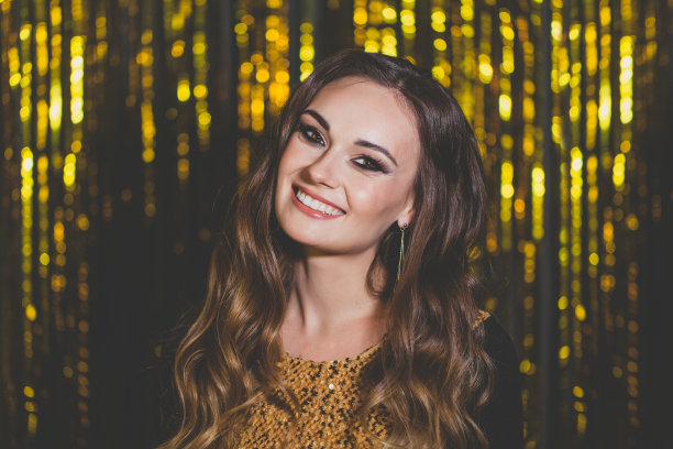 美丽的女人名人在金色散景背景上化妆图片下载