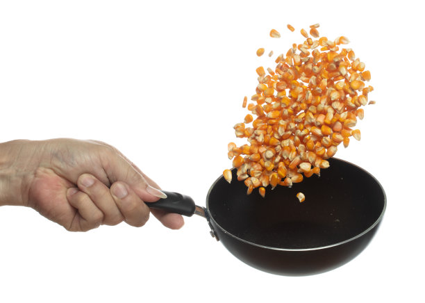 玉米干种子谷物飞在锅爆米花。金黄色的玉米种子落散，爆炸成线团漂浮。白色背景隔离冻结运动高速快门图片下载