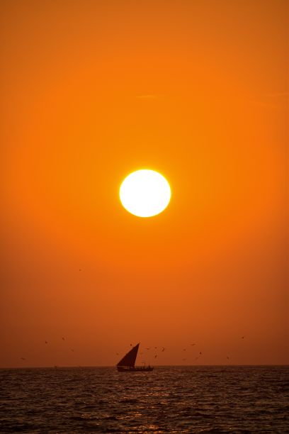 小帆船的剪影在一个惊人的日落在开阔的海上图片下载