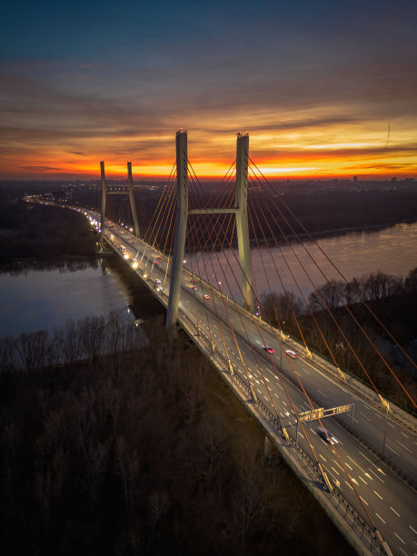 波兰华沙的一座桥，在夜晚横跨一片宁静的水域图片下载