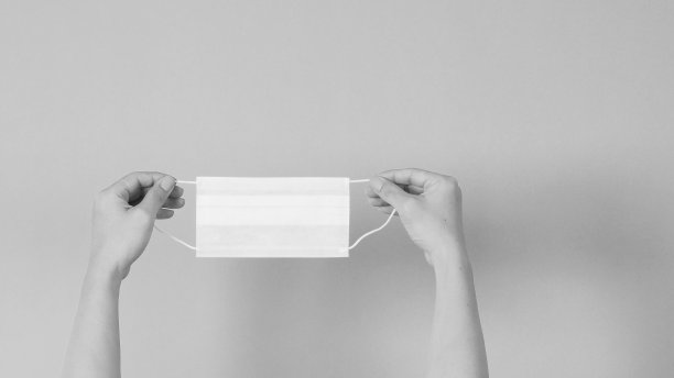 手拿白色面膜薄荷或蒂芙尼蓝背景。黑白照片。图片下载