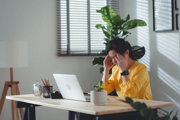 亚洲女性坐在家里头疼。图片下载