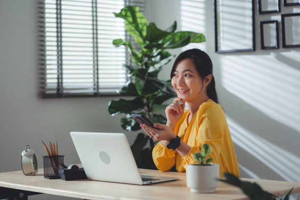亚洲女性喜欢在家里办公时在线工作和使用智能手机。图片下载