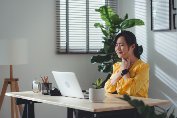 亚洲妇女发烧，喉咙痛，坐在家里办公。图片下载