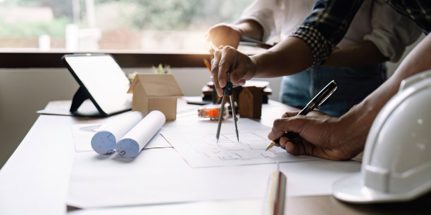 工程师和建筑师开会工作，手绘蓝图，并与他的同事进行简报。工程工具和施工概念图片下载