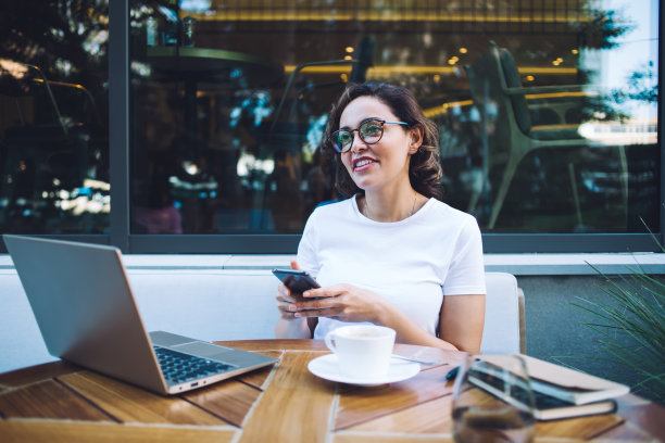 微笑的经理在咖啡馆附近用智能手机发短信图片下载