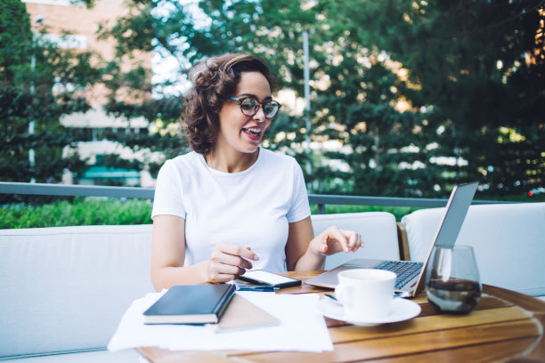 开朗的女人在户外餐厅用笔记本电脑工作图片下载