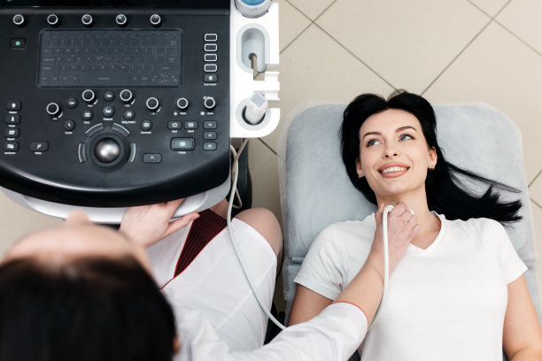 年轻女性病人在甲状腺超声检查期间躺在医务室的沙发上图片下载