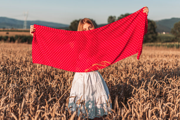 户外照片，年轻的姜黄色女孩在白色连衣裙拿着红色围巾图片下载