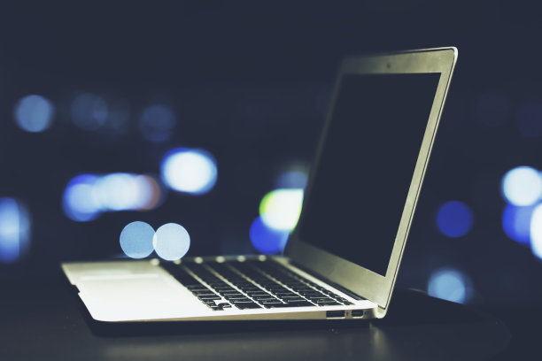 笔记本电脑和夜晚的城市景观模糊图片下载