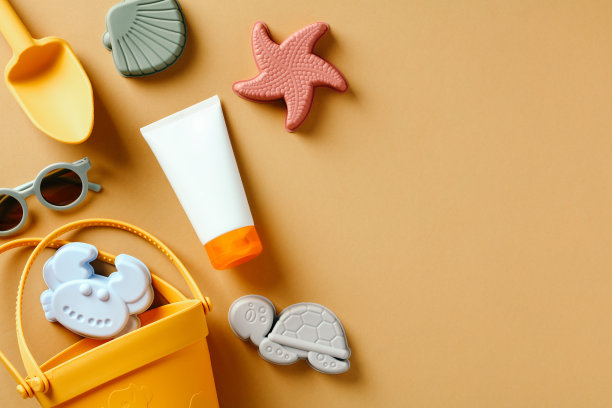 儿童的沙模，太阳镜，米色背景上的防晒霜图片下载