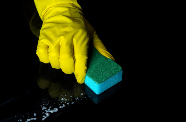 用蓝色的毛巾手洗黑色的桌子。一个家庭清洁过程的特写镜头。冠状病毒感染期间的卫生保健及消毒理念。图片下载