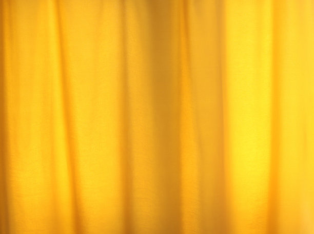漂亮简单的黄色窗帘与褶皱波纹背景。轻窗帘覆盖室内背景图片下载