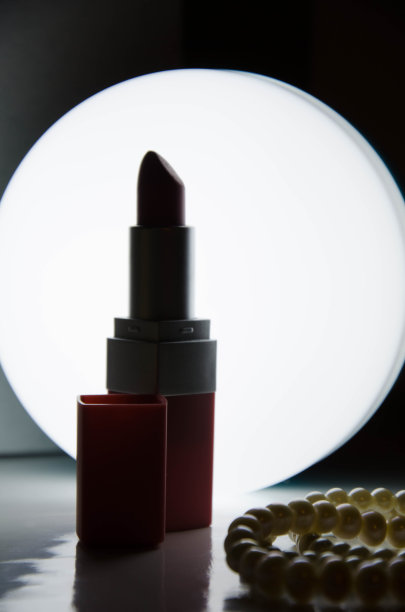 口红和珍珠手镯放在灯的前面图片下载