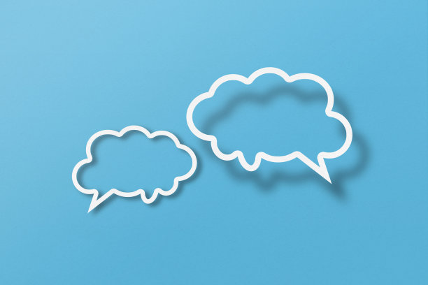 白纸剪出的语音泡泡形状设置在浅蓝色的纸背景上。图片下载