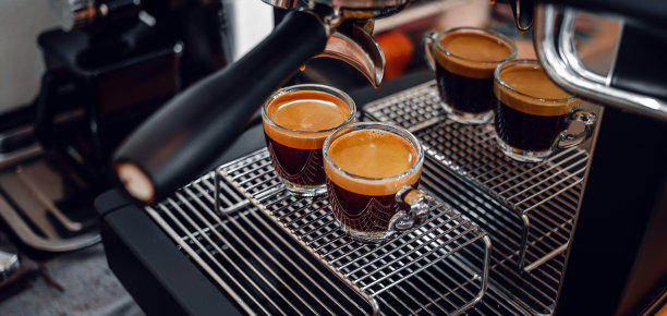 在咖啡店准备两杯浓缩咖啡时，专业的浓缩咖啡机。浓缩咖啡从咖啡机倒出来的特写镜头图片下载
