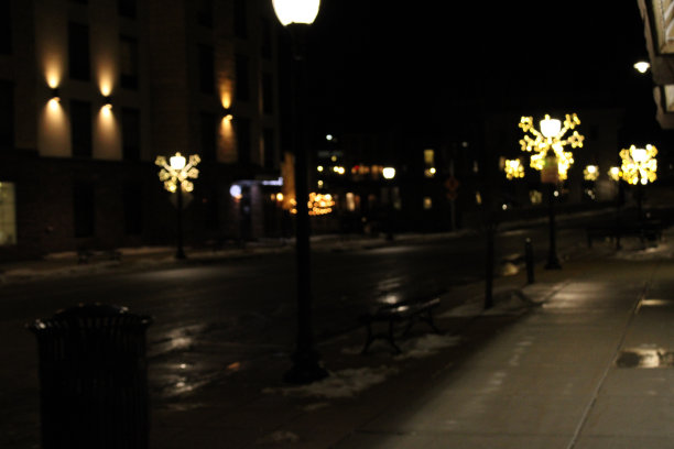 市中心被建筑物包围的灯火通明的街道图片下载