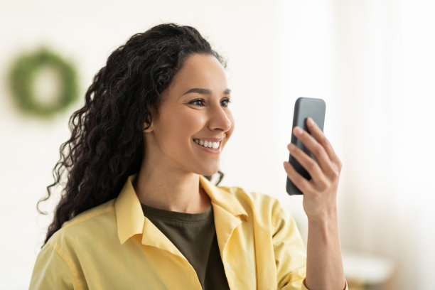 在家中使用智能手机的年轻微笑女人特写图片下载
