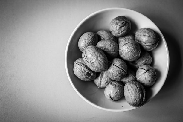 整个核桃放在白色的碗里。带壳核桃的健康零食图片下载