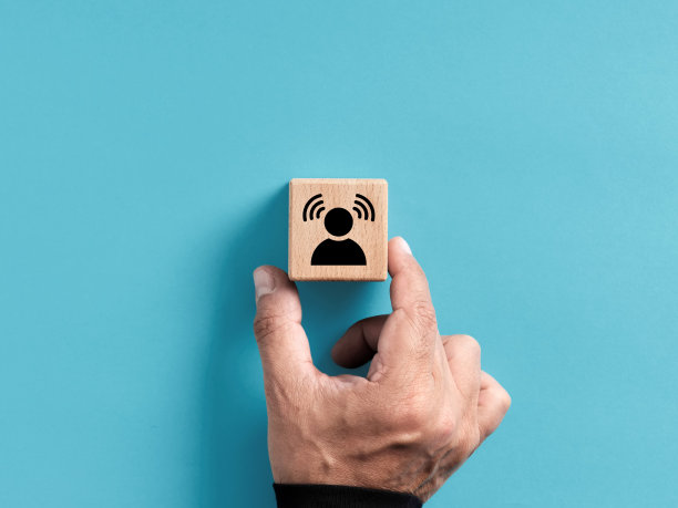 品牌知名度。在商业营销中建立客户意识。手放置有个人意识图标的木制立方体。图片下载