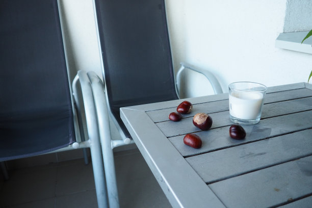 栗子水果在桌子上。阳台或露台上的桌椅。季末在酒店。这张桌子被漆成银色。图片下载