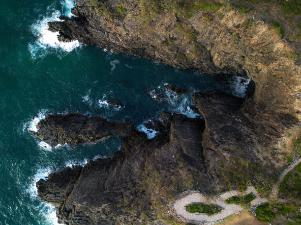 鸟瞰风景优美的岩石海岸线，背景是美丽的蓝色海水图片下载