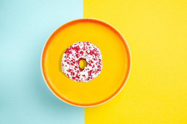 黄色盘子上的甜甜圈照片。俯视图照片。咖啡馆或糕点店的广告。现代食品概念。图片下载