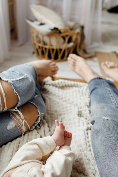 全家福脚近摄。年轻的一家人正躺在床上。妈妈，爸爸和宝宝。人们喜欢有他们的陪伴。童年和为人父母。休闲的生活方式。高质量照片图片下载