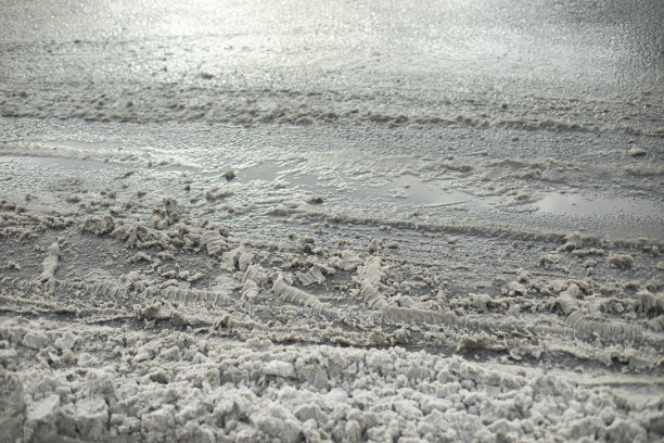 路上有融化的雪。融化的泥浆。冬天的沥青细节。图片下载