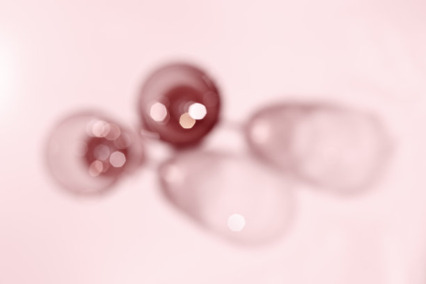 红色的玫瑰酒近距离模糊上粉红色的背景，抽象的玫瑰酒背景，自然的光影，眩光和闪光的散景纹理，美观的壁纸。节日的概念图片下载