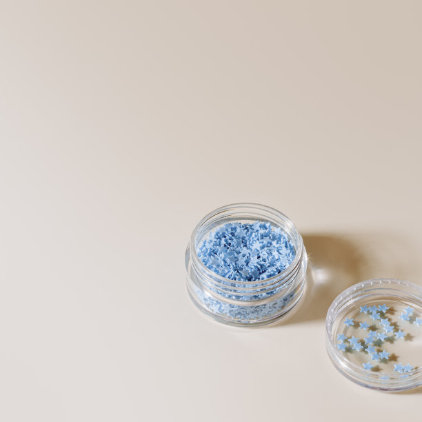 元素为指甲装饰，蓝色星星在指甲配件盒，星星为指甲艺术在玻璃罐米色背景，文案空间。创意美的理念，色彩柔和的照片，视觉内容图片下载