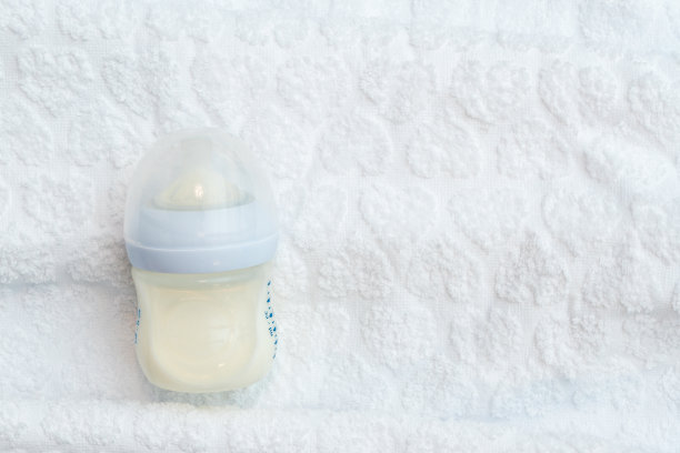 有复制空间的白毛巾上放着一瓶半空的营养牛奶图片下载