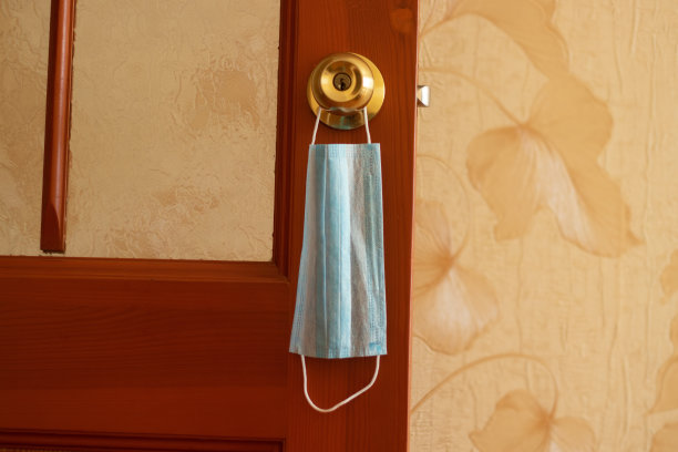 医用口罩挂在一个房间的门把手上图片下载