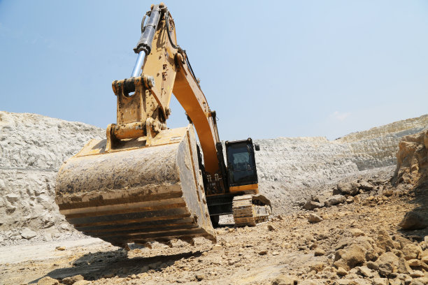 在天空背景下，挖掘机铲斗正在施工现场挖土图片下载