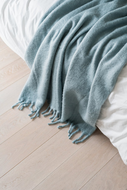 蓝色床的特写，在酒店房间的床上扔被子图片下载