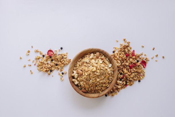 白色背景上有坚果和杏仁的格兰诺拉麦片，麦片散落在周围图片下载