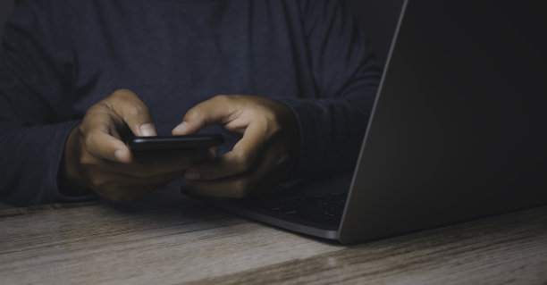 商人使用智能手机和笔记本电脑。图片下载