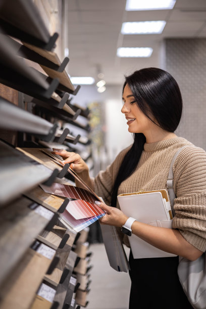 快乐的黑发女性室内设计师在商店选择地板瓷砖颜色纹理样品图片下载
