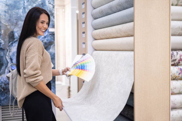 微笑的女室内设计师选择壁纸与彩色样品室内装修作品图片下载