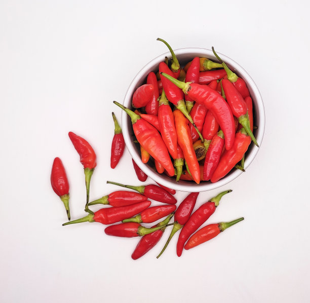 红辣椒、辣椒粉或凯布辣椒在碗里单独放在白色背景上图片下载