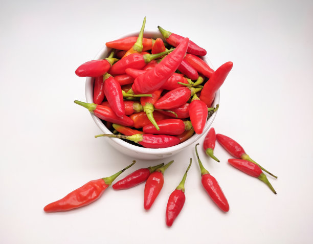 红辣椒、辣椒粉或凯布辣椒在碗里单独放在白色背景上图片下载