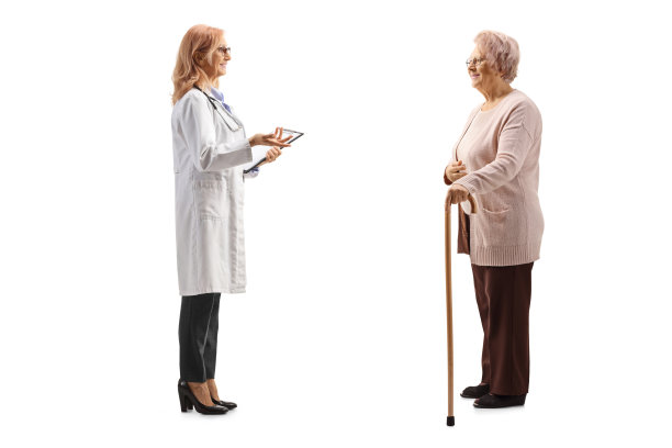 一名女医生与一名老年女病人交谈的全长侧面镜头图片下载