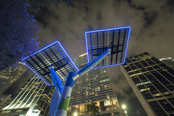 蓝色太阳能光伏板安装在现代城市的街杆上，为路灯和监控摄像头供电。佛罗里达州迈阿密市中心的未来能源来源图片下载