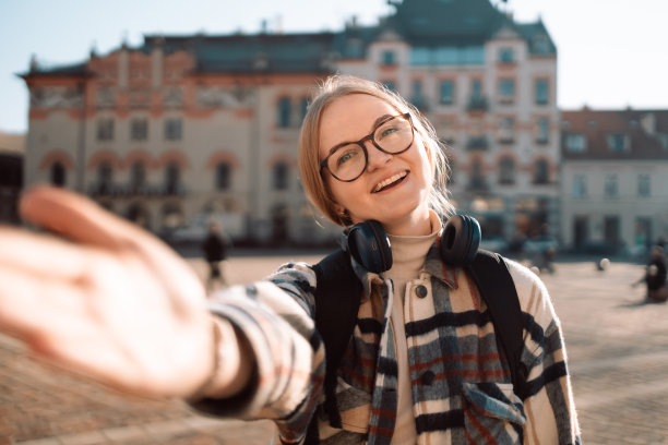 年轻女孩在春城大街上用手机自拍。城市生活理念。图片下载