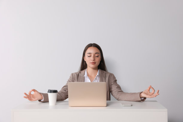 找到禅。妇女在白墙附近的桌子上休息图片下载