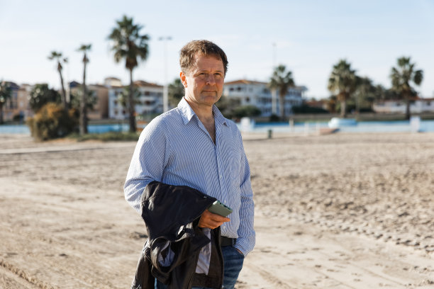 商人打电话，使用智能手机手机应用程序发短信，浏览社交媒体技术，站在城市的现代街道上。图片下载